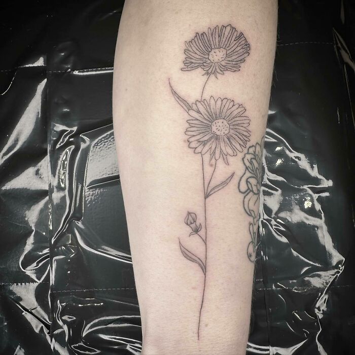 Delicate flower tattoo on forearm, showcasing elegance and beauty with simple line work.