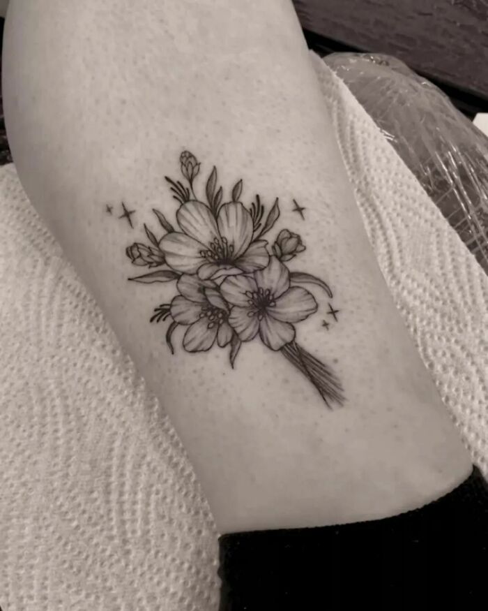 Elegant flower tattoo design showcasing intricate blooms on skin.