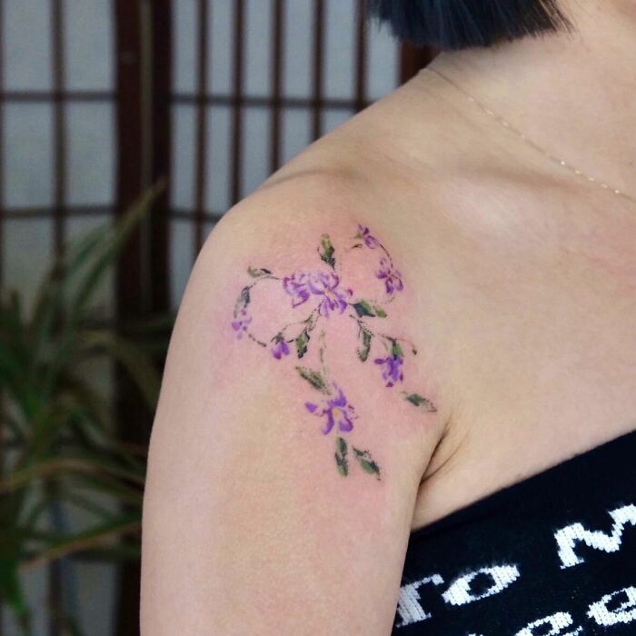 Watercolor ribbon shaped flowers tattoo