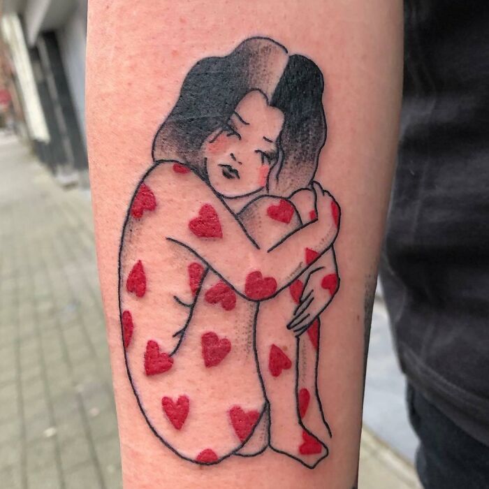 Self-love tattoo of a figure with red hearts on skin, embracing themselves on an arm.