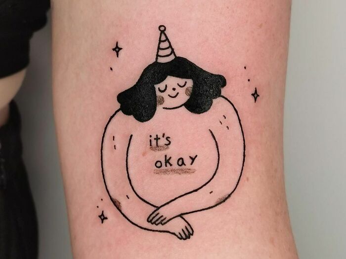 It's okay and person smiling arm tattoo