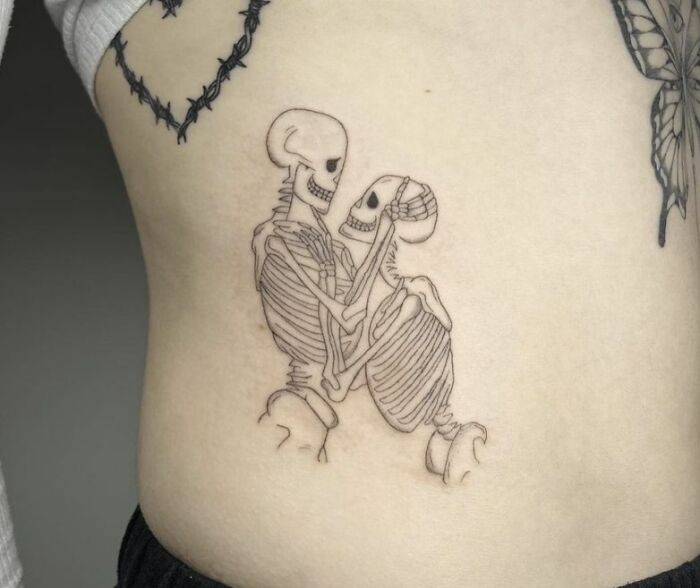 Skeleton couple tattoo design symbolizing self-love on skin.