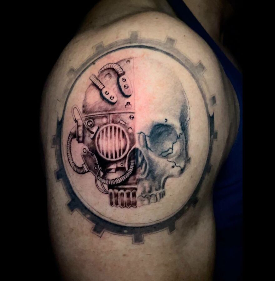Cog mechanicus skull tattoo showcasing super realistic detailing on an upper arm.