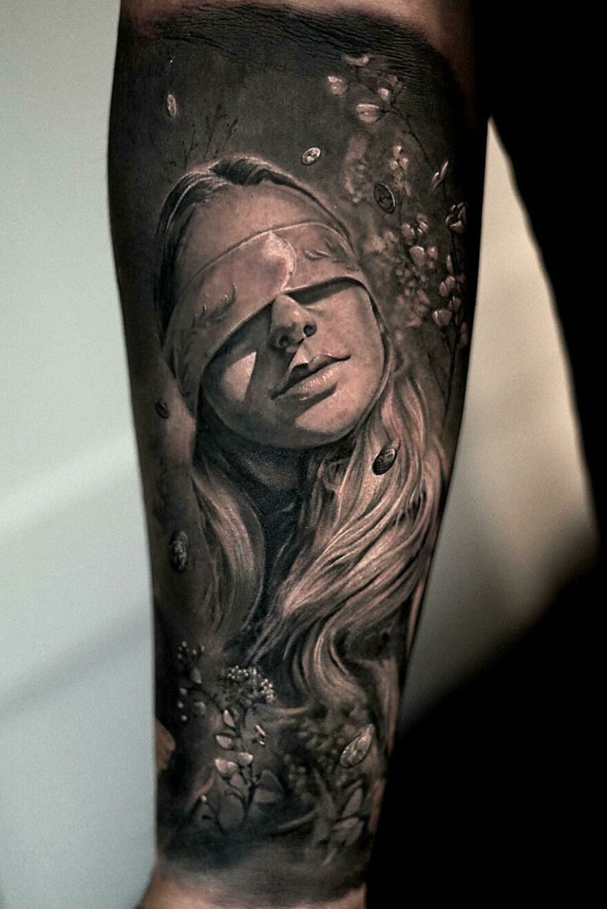 Super realistic tattoo of a young woman with eyes covered, showcasing intricate detailing.