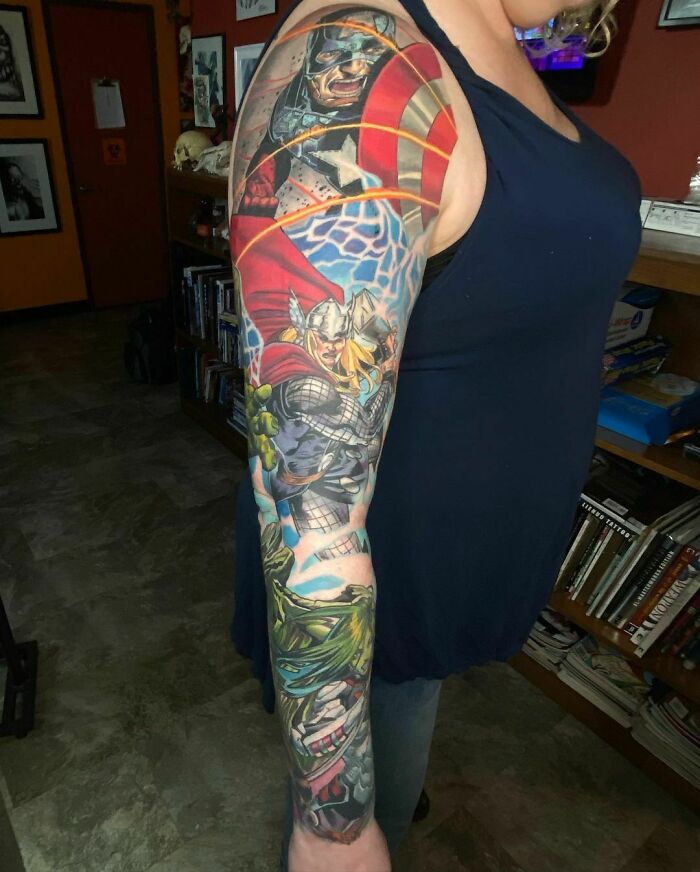 Arm tattoo featuring Marvel superheroes in vivid colors, showcasing a passion for Marvel.