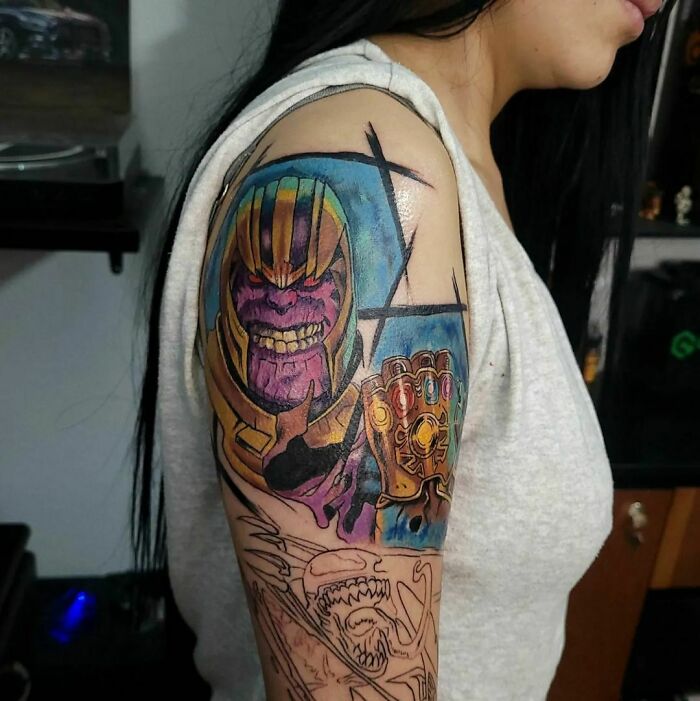 Arm tattoo featuring Marvel's Thanos with the Infinity Gauntlet, showcasing vibrant colors and intricate details.