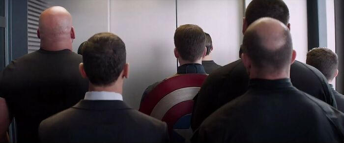Captain America in the elevator with agents 
