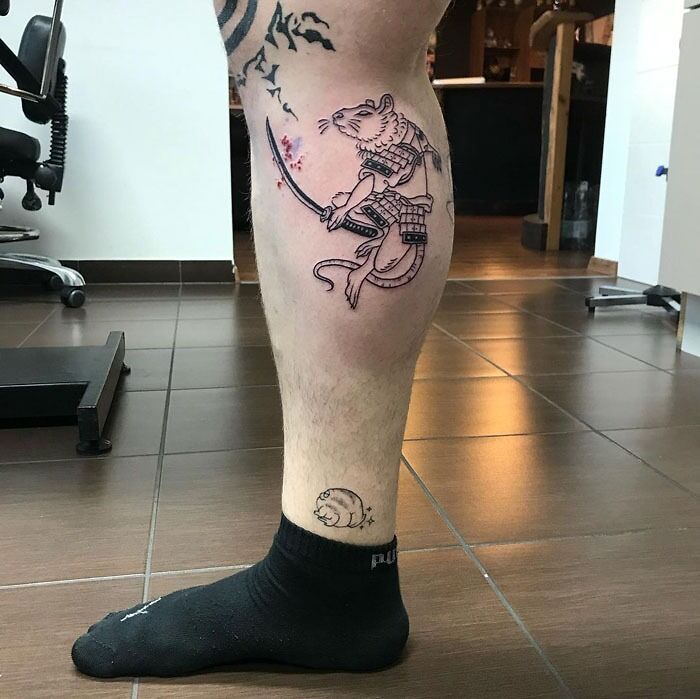 Unique calf tattoo featuring a warrior mouse with a sword in a modern studio setting.