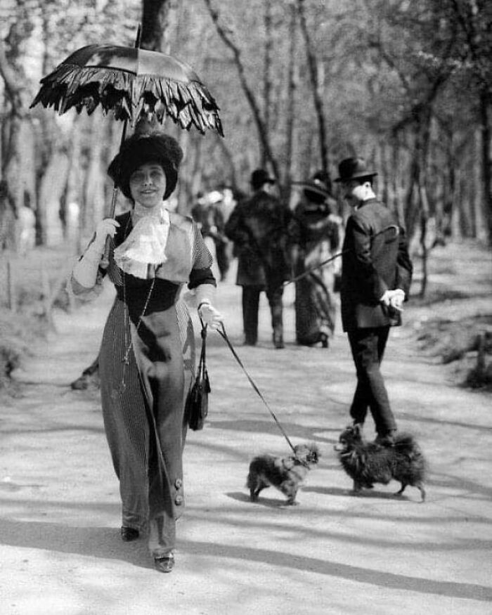 Una mujer elegante paseando a su perro en el Bois de Boulogne de París, 1910
