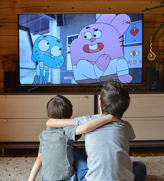 Children's hugging while watching TV sitting together on floor