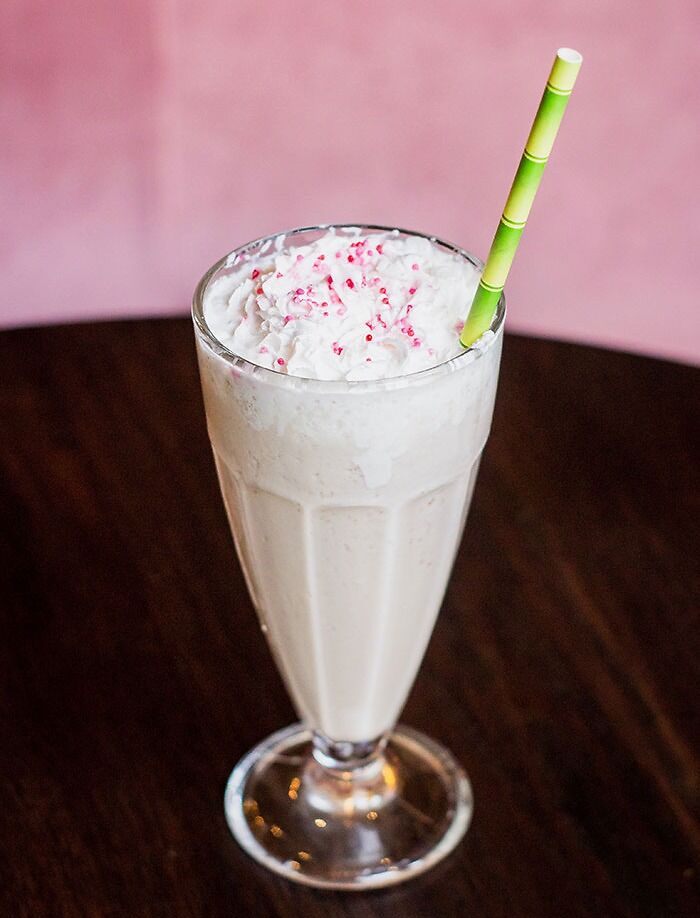 Photo of white milkshake with green straw