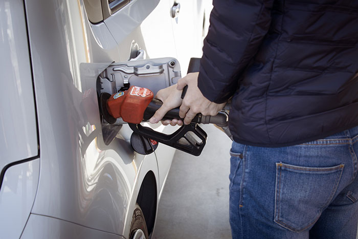 Person filling car with gas