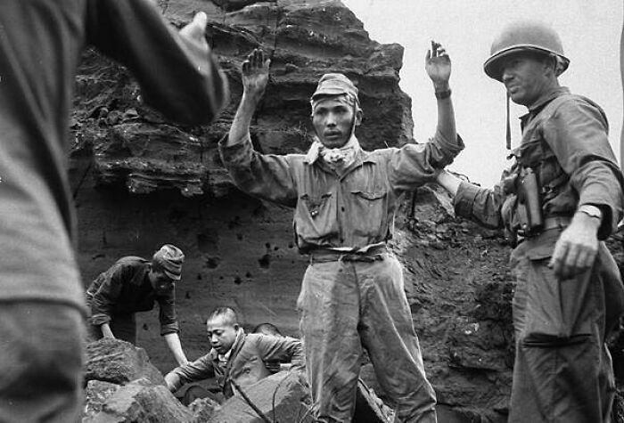 With His Hands In The Air, The First Of 20 Japanese Emerges From A Cave On Iwo Jima On April 5, 1945. The Group Had Been Hiding For Several Days