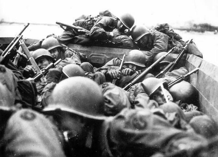 American Soldiers Aboard An Assault Boat Huddle Together As They Cross The Rhine River At St. Goar, Germany, While Under Heavy Fire From The German Forces In March Of 1945