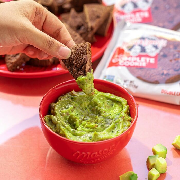 Chocolate cookie dipped in guacamole