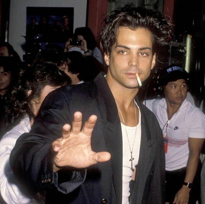 Richard Grieco looking at someone with a cigarette in his mouth 
