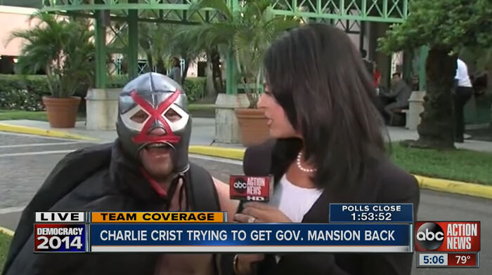 Woman interviewing man wearing a mask
