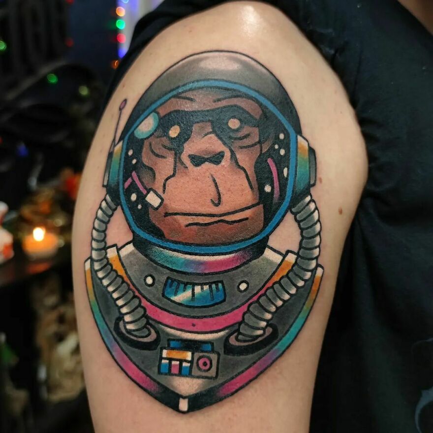 Colorful astronaut chimpanzee arm tattoo