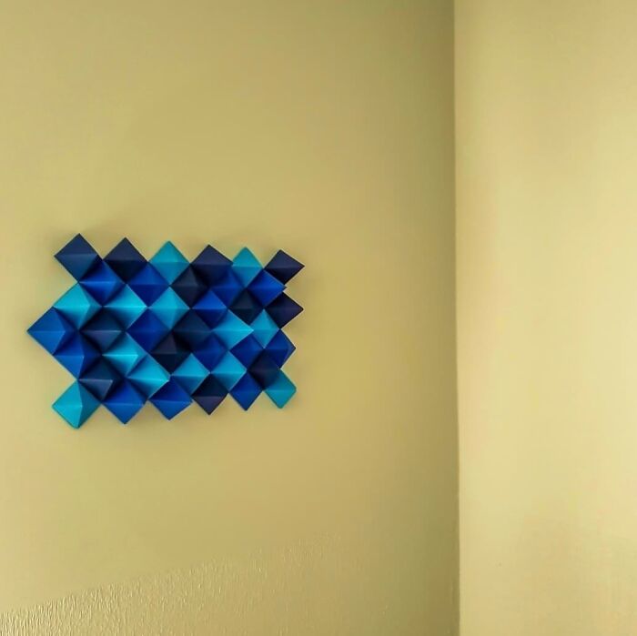 blue modular origami on a yellow wall