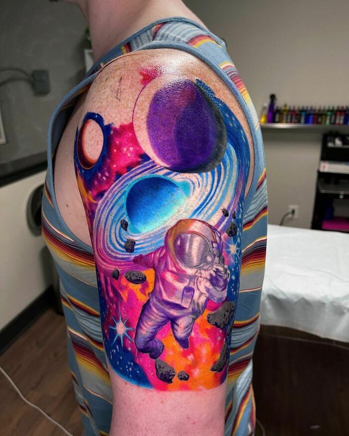 Watercolor astronaut in space arm tattoo