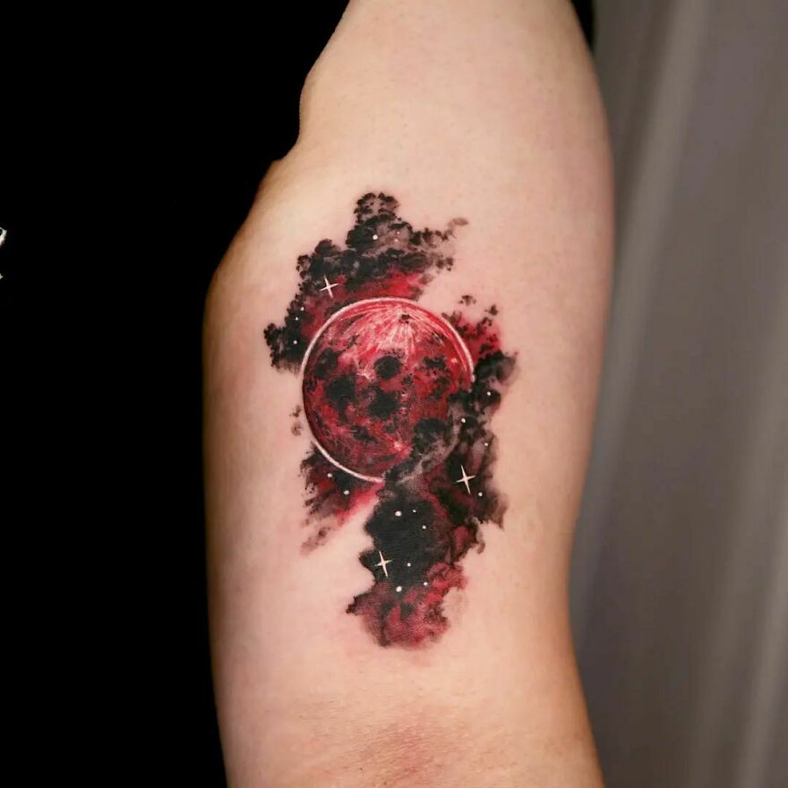Red moon and clouds arm tattoo