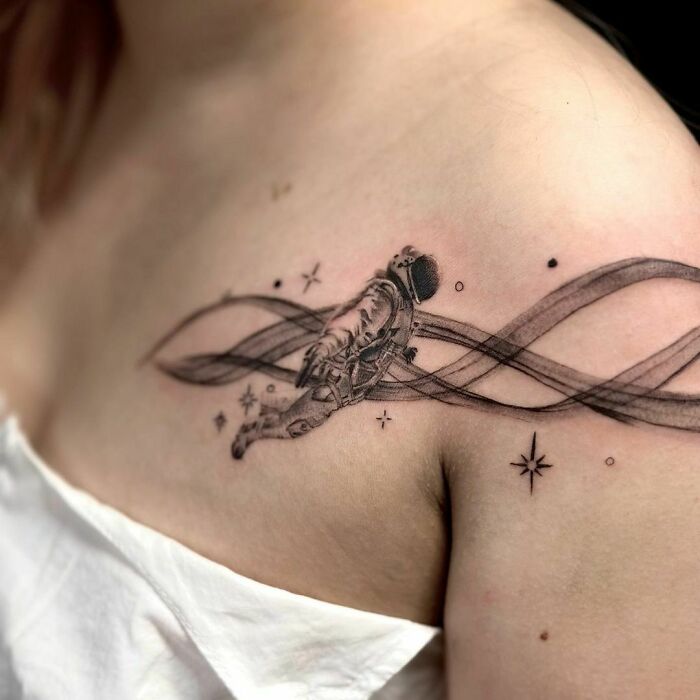 Floating astronaut shoulder tattoo