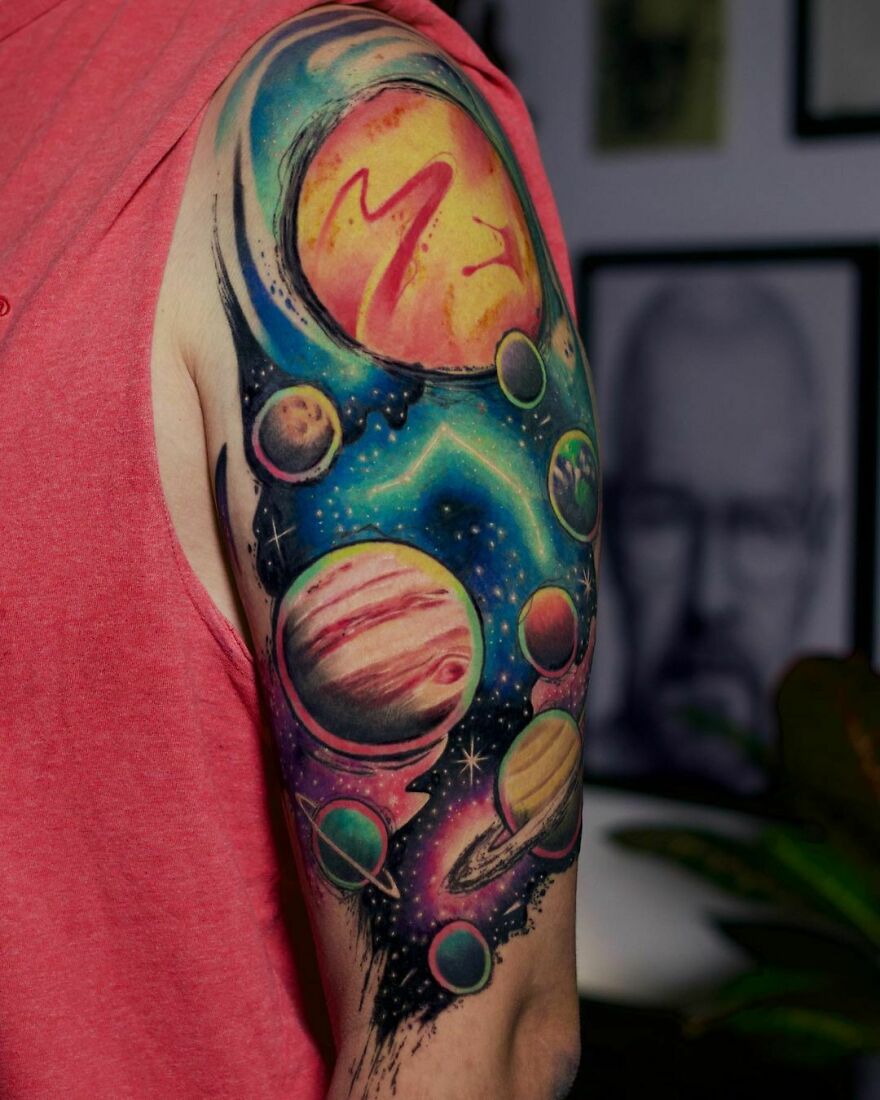 Colorful planets in space arm tattoo
