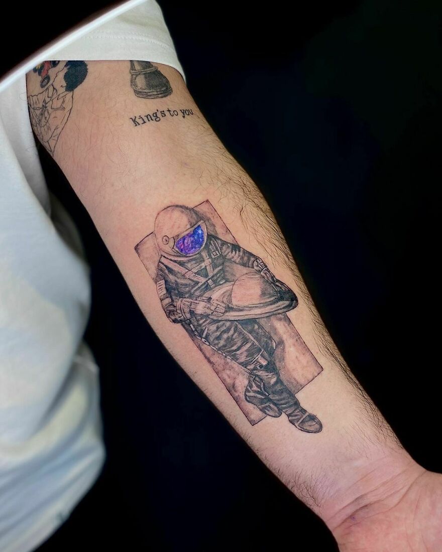 Astronaut holding Saturn forearm tattoo