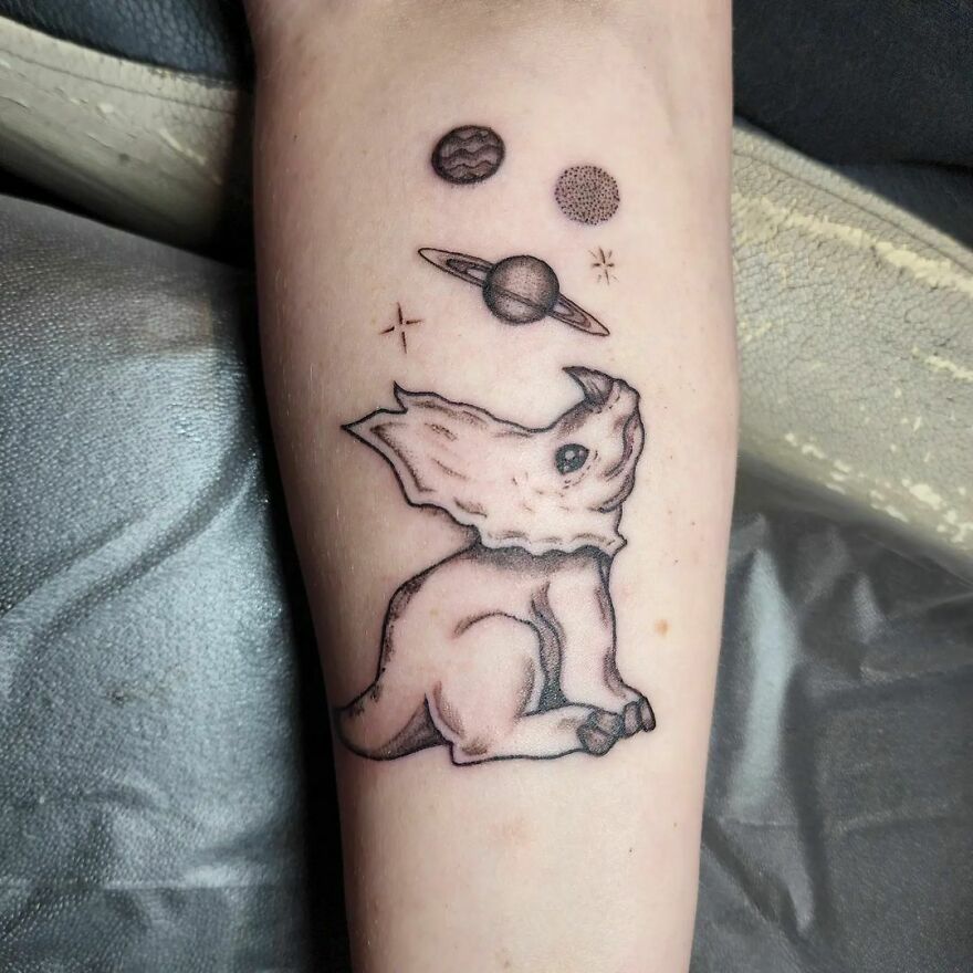Dinosaur and planets forearm tattoo