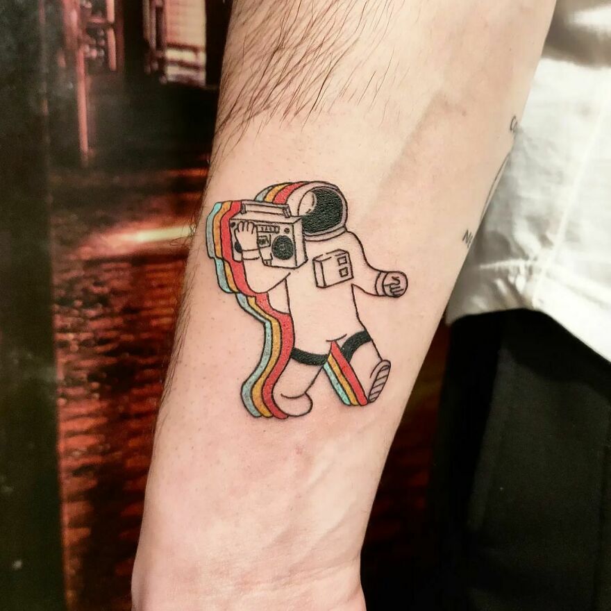 Funny astronaut holding a radio forearm tattoo