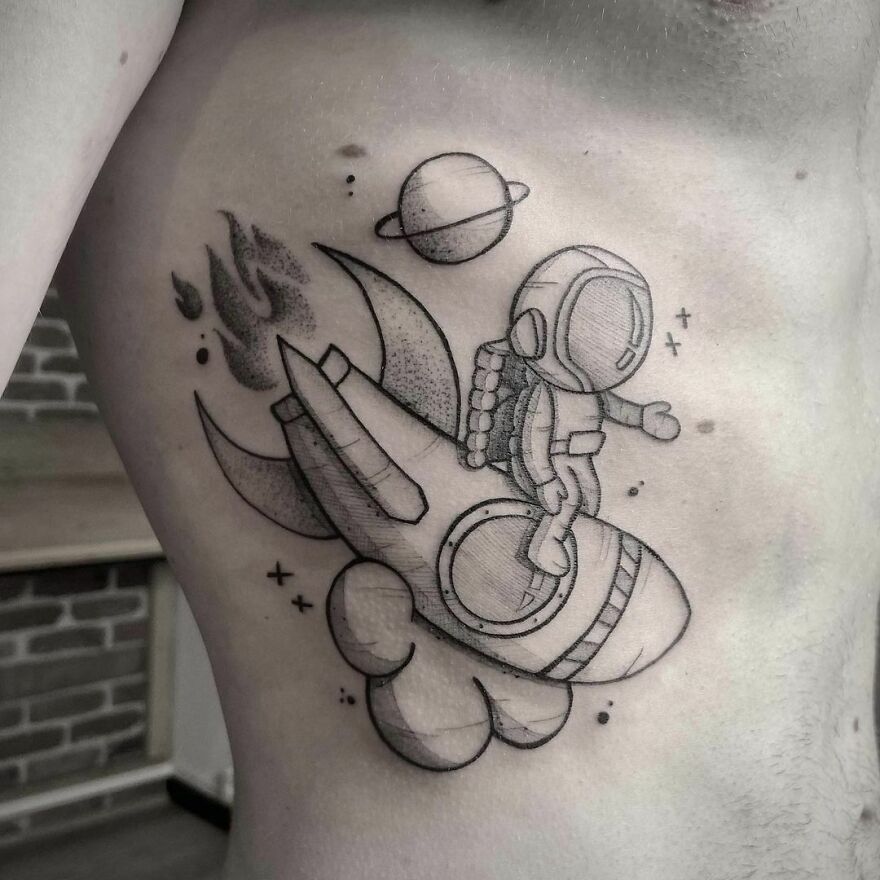 Cute astronaut on a spaceship ribs tattoo