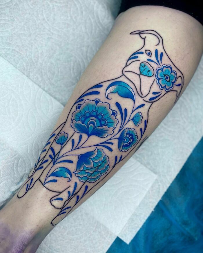 Blue floral dog calf tattoo design, showcasing unique style and vibrant colors.