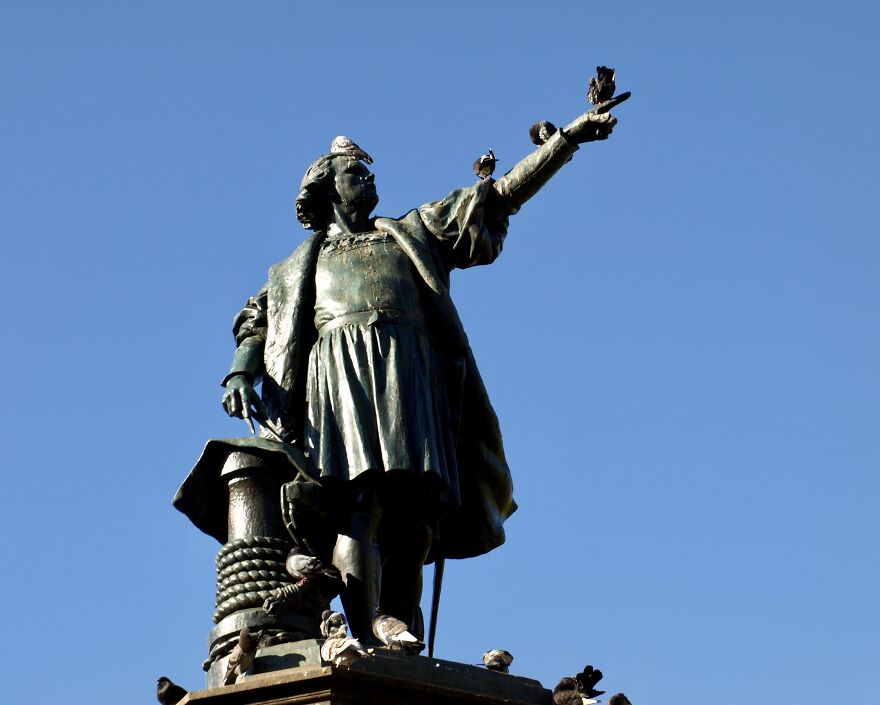A Statue Of Christopher Columbus (Cristobal Colon) With Pigeons Perched On It