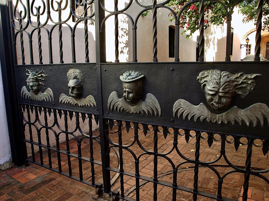 Interesting Faces On An Iron Gate In An Alleyway In La Zona