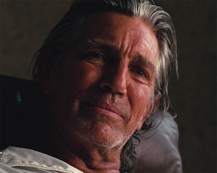 Eric Roberts lying in the bed and looking in the movie