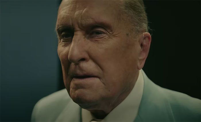 Robert Duvall wearing suit and looking in the movie