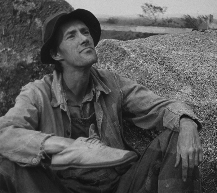 John Carradine sitting and holding shoe in movie The Grapes of Wrath