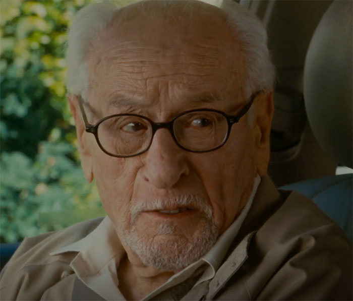 Eli Wallach wearing glasses and looking in movie