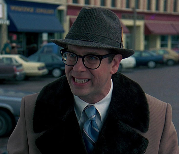 Stephen Tobolowsky wearing hat, glasses and brown clothes in movie