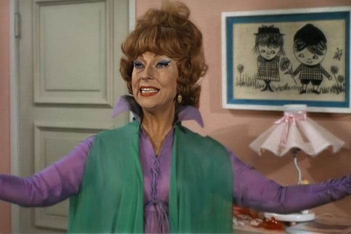 Endora with her hands spread is in a room