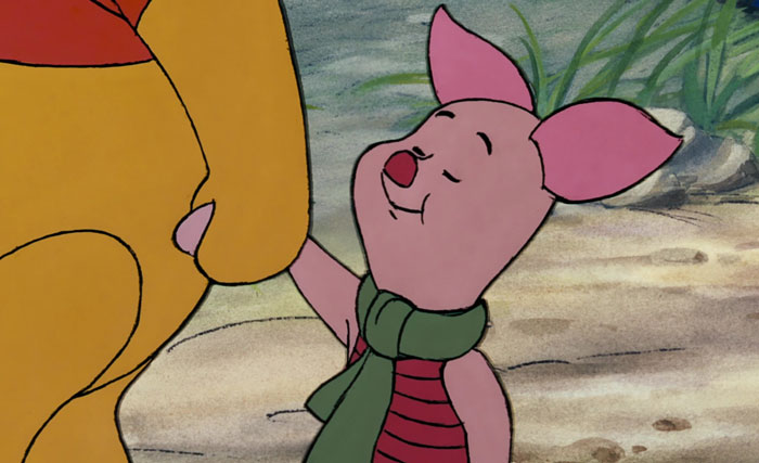 Piglet from a cartoon smiling with eyes closed, wearing a green scarf, in a thoughtful interaction.