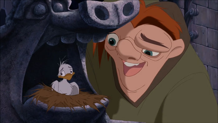 Quasimodo smiling while looking at a small bird