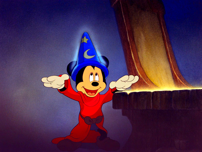 A cartoon character in a wizard outfit, standing with arms raised next to an ancient book.