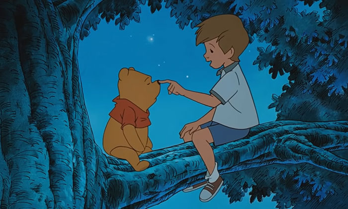 A boy and a bear sit on a tree branch under the stars, illustrating how cartoon quotes can fit real life situations.