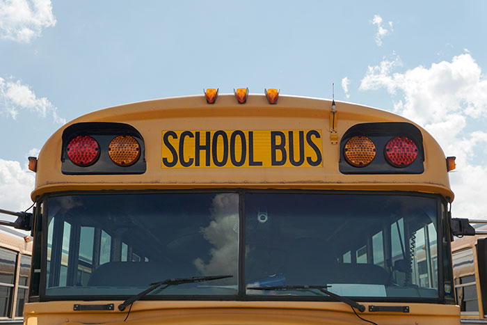 Front windshield and lights of a traditional yellow school bus