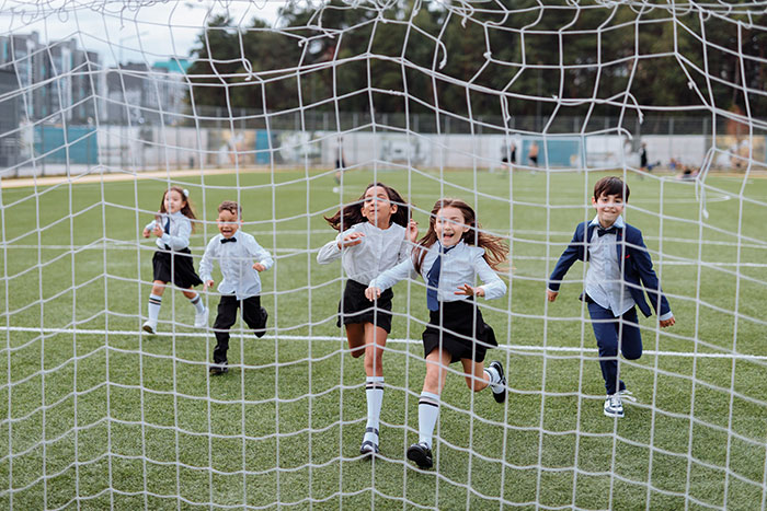 Children running towards the soccer net