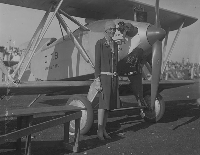 photo of Amelia Earhart near the plane