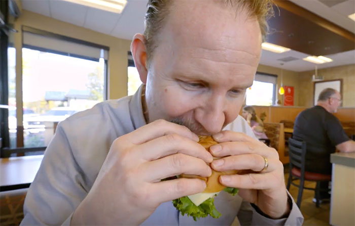 Super Size Me character eating burger