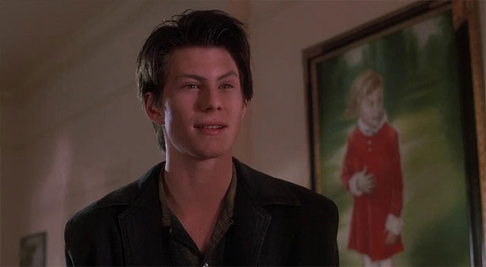 Christian Slater looking at someone in a room 