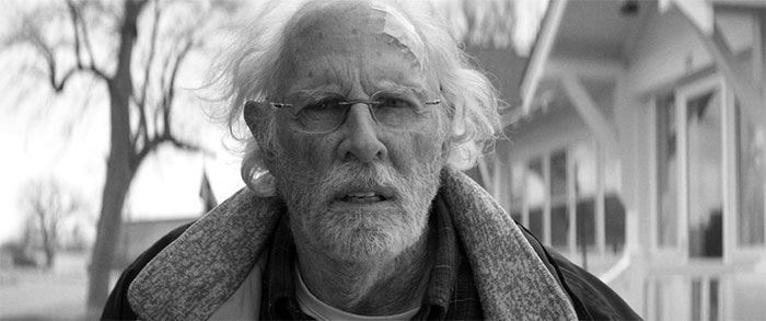 Bruce Dern looking at someone with a patch on his forehead 